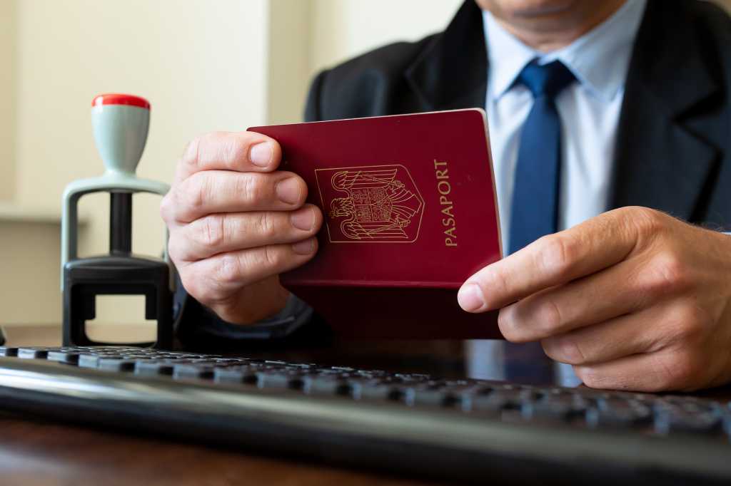 Custom officer checking a travelling passport. Screening of passengers, travellers for Chinese Covid-19 coronavirus symptoms  in International airports.